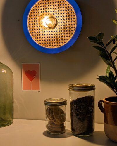 Luminaire artisanal en cannage peint dans un bleu intense, proche du bleu Klein.